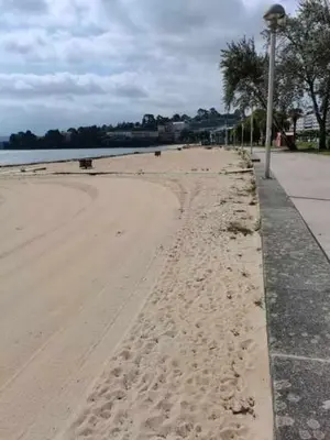 a beach with footprints in the sand next to the water at Apartamento Carreira Sada in Sada