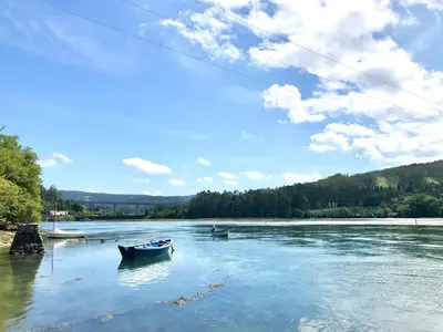 two boats in the water on a river at The Cliffs - Sunset Village Beach 3C in Viveiro