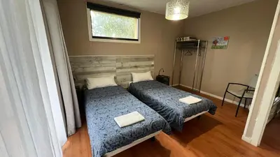 a bedroom with two beds and a window at CASAPUEBLO Arzúa in Campo