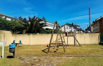 a swing set in a yard next to a fence at Indiano 2K in Viveiro