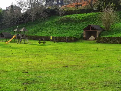 a park with a playground with a slide and a play structure at Indiano 2K in Viveiro