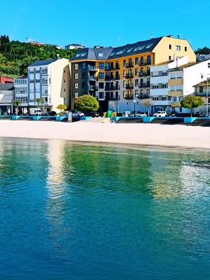 a view of a beach with buildings and the water at Casa do Xuli in Viveiro