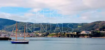 a boat in a body of water with a town in the background at Casa do Xuli in Viveiro
