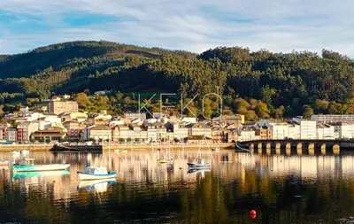 a small town on a lake with boats in the water at Casa do Xuli in Viveiro