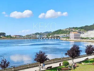 a view of a river with people walking on a sidewalk at Camiño Vello in Viveiro