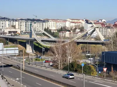 a bridge over a highway in a city with buildings at Piso termal III in Ourense