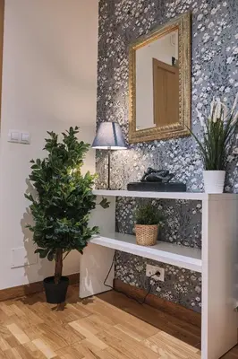 a mirror on a wall next to a table with a plant at Pensión A Solaina 2 in O Pino