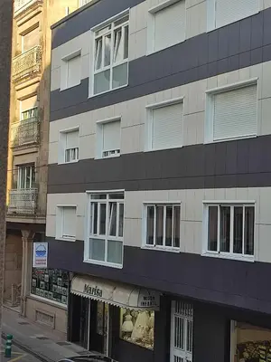 a tall building with windows on a city street at Apartamento TerradeAugas3 in Caldas de Reis