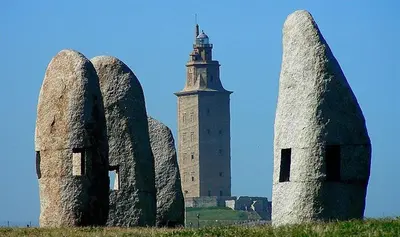 a building with a clock tower and some stone statues at Stone Cottage La COMPOSTELANA in Curtis