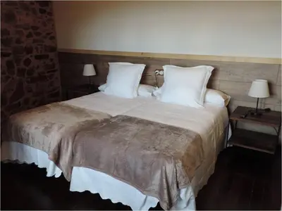 a bedroom with a large bed with white pillows at El Rincón Maragato in Castrillo De Los Polvazares