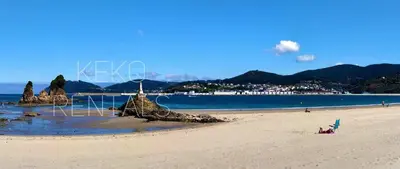 a beach with a group of rocks in the sand at La Casa de Ana in Viveiro