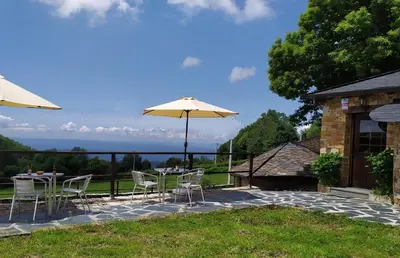 a patio with a table and chairs and an umbrella at O Busto Aldea Rural, Apartamento HORNO 2 in A Pobra do Brollon