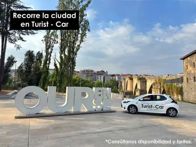 a white car parked in front of a sign at O cuarto de abastos in Ourense