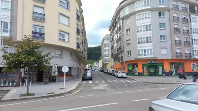 a city street with cars parked on the side of buildings at Miramar in Viveiro